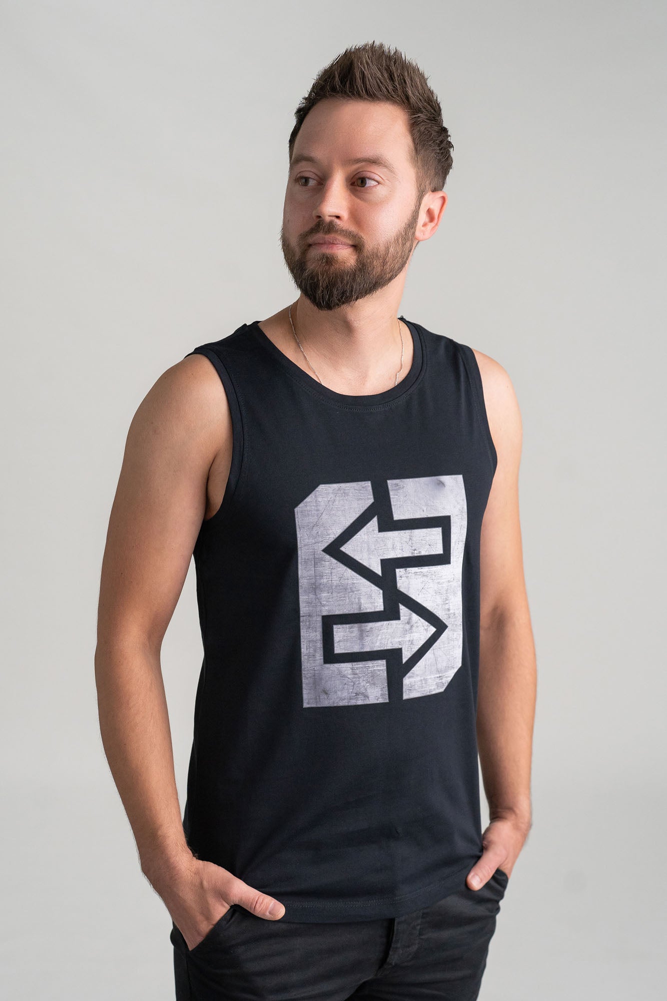 Ein Mann trägt ein schwarzes Tanktop mit einem Logo, ideal für heiße Tage und sportliche Aktivitäten.