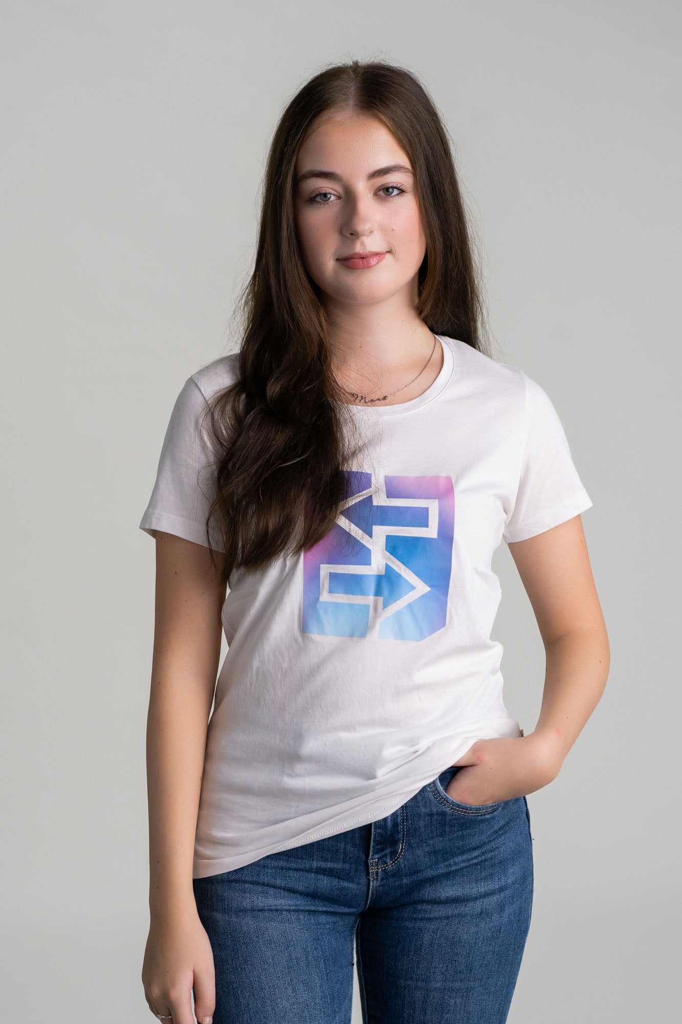 Eine Frau trägt ein weißes T-Shirt mit einem blauen und pinken Logo, ideal für den Miami-Lifestyle und strahlende Sonnenuntergänge.