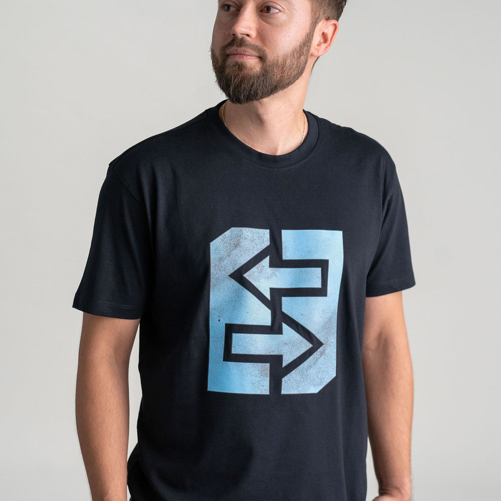 Ein Mann trägt ein schwarzes T-Shirt mit einem blauen Logo, inspiriert von griechischer Mythologie und Geschichte.