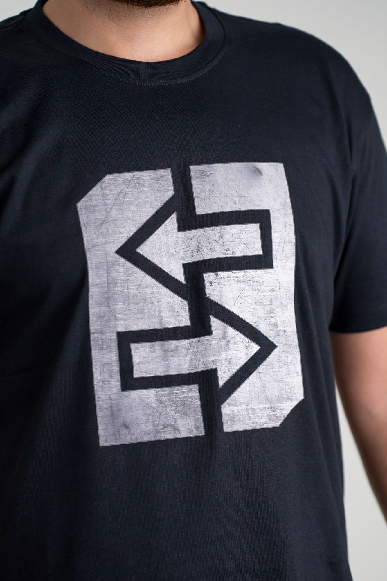 T-Shirt mit grauem Logo, das Stärke und Unzerstörbarkeit ausstrahlt. Ideal für Werkstatt und Freizeit.