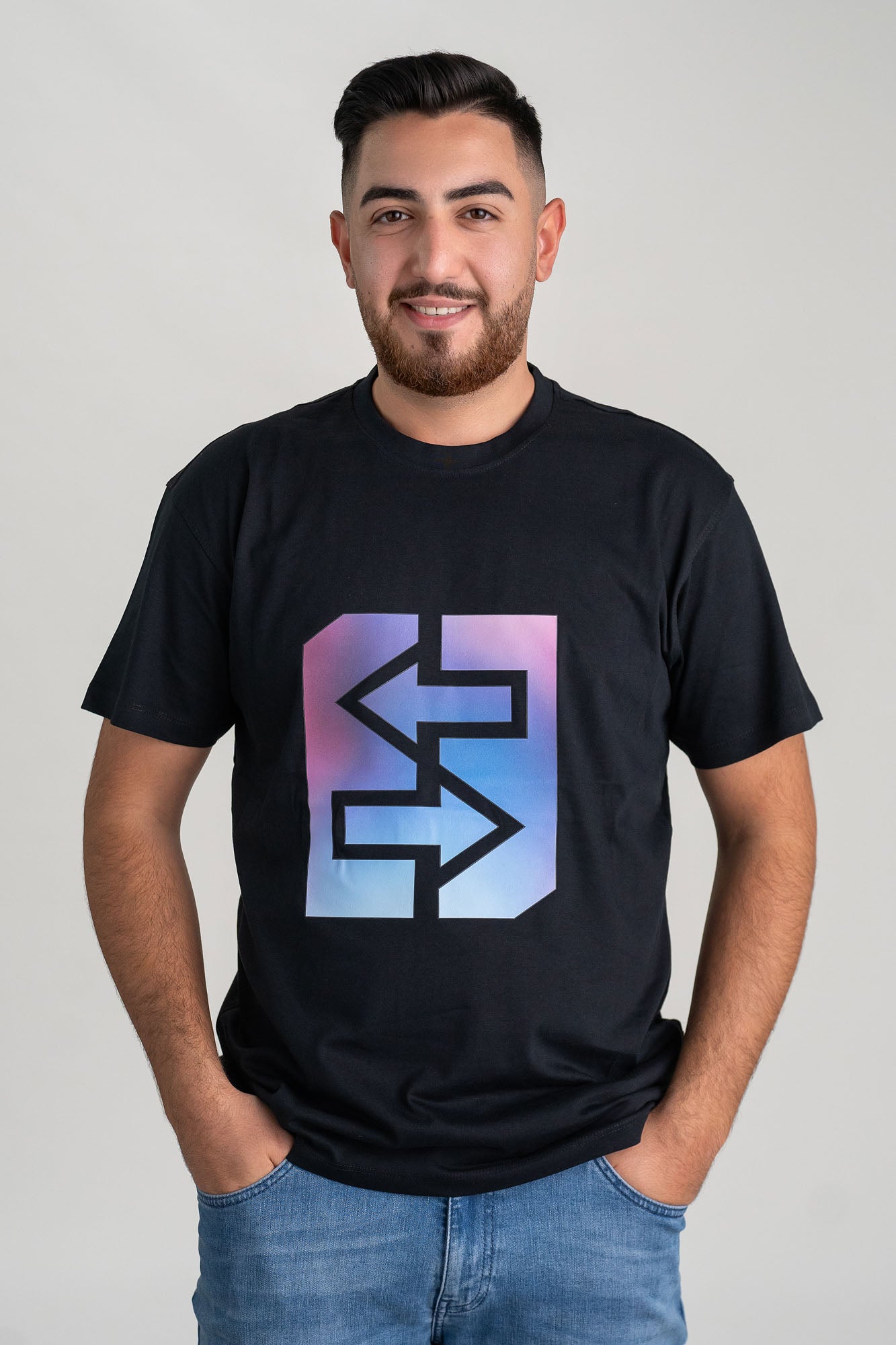 Ein lächelnder Mann trägt ein schwarzes T-Shirt mit lila-blauem Logo, das den Miami-Lifestyle verkörpert.
