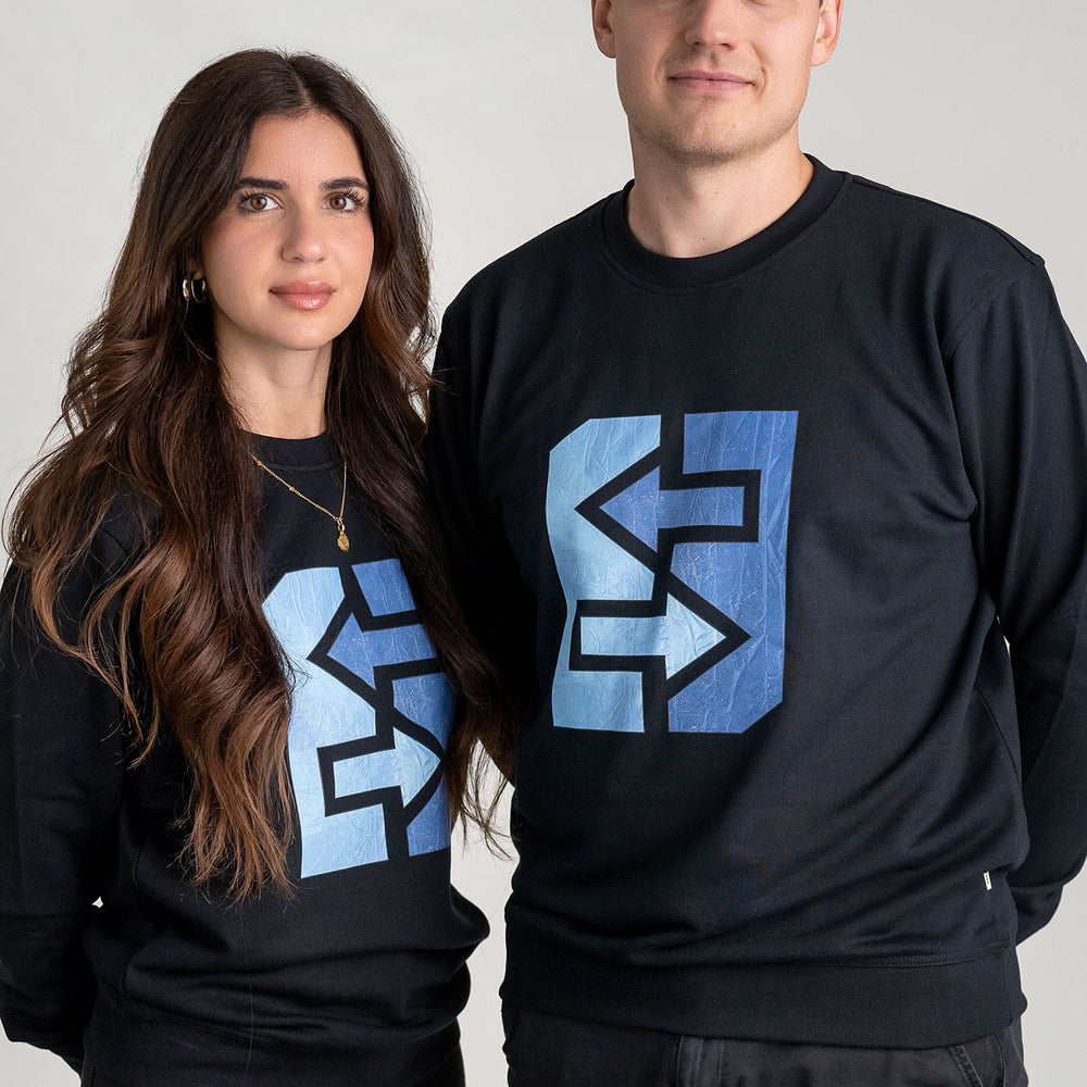 Ein Mann und eine Frau sind in schwarzen Sweatshirts mit dem Firmenlogo gekleidet, perfekt für die kühlen Tage in Oslo.