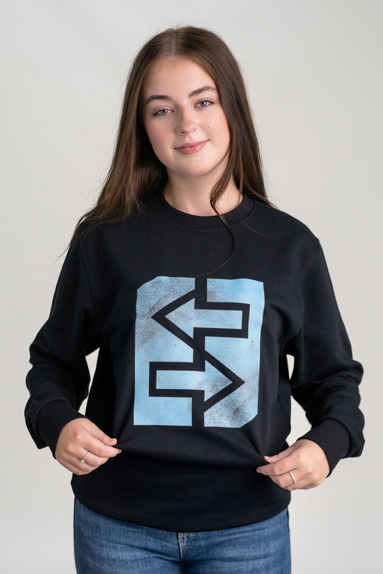Ein Mädchen trägt ein schwarzes Sweatshirt, inspiriert von griechischer Mythologie und Geschichte.