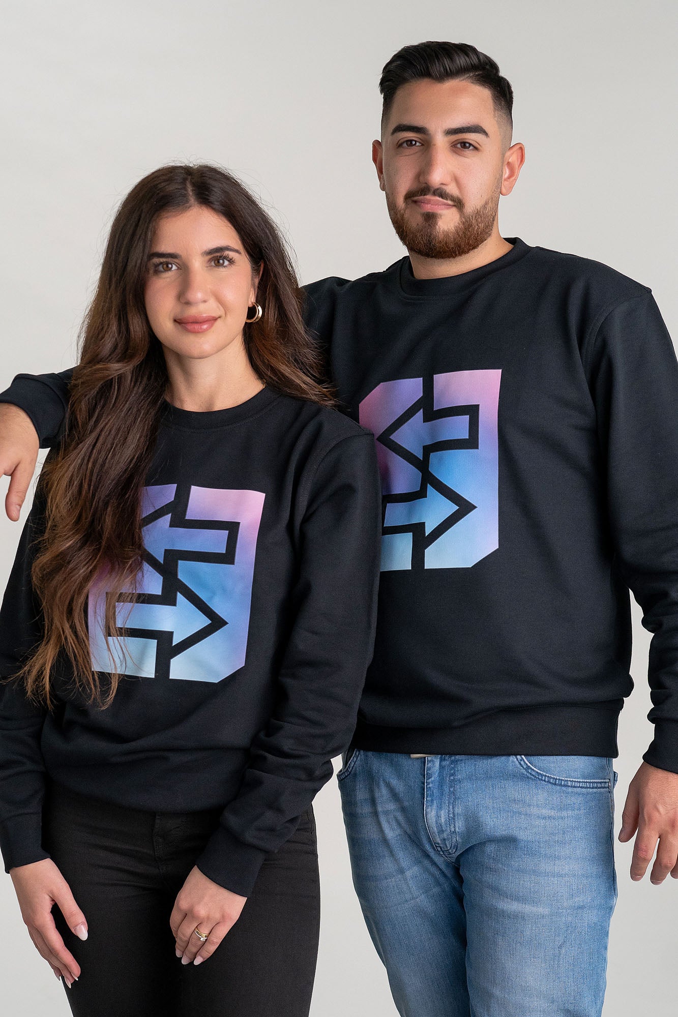Ein Mann und eine Frau trägt ein schwarzes Sweatshirt mit Regenbogenmotiv, ideal für den Miami-Lifestyle und die Abendsonne.