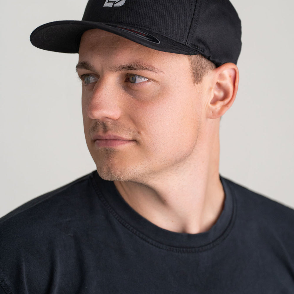 
                      
                        Junger Mann trägt eine Flexfit Cap Schwarz
                      
                    