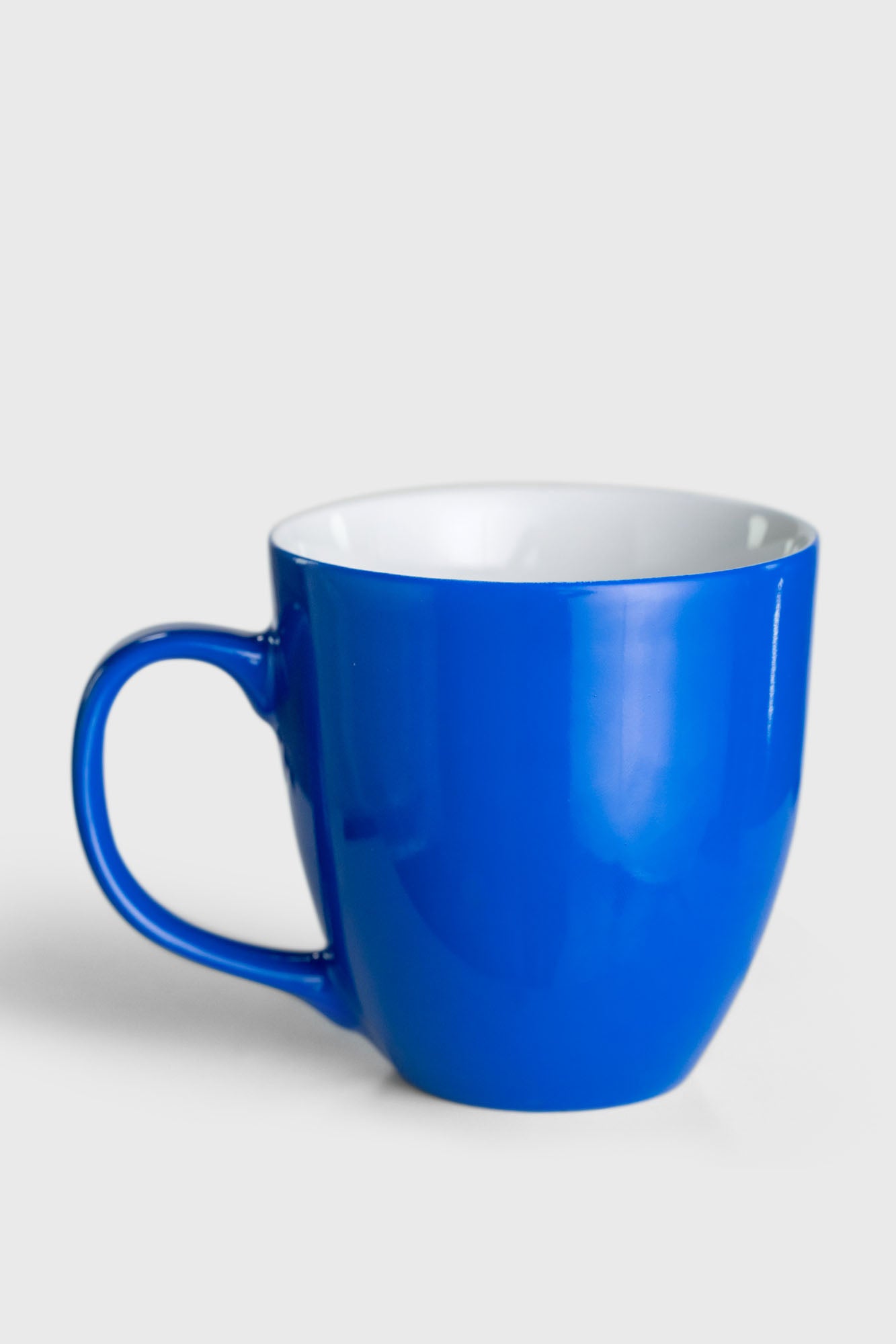 Ein blauer Kaffeebecher mit weißem Rand, ideal für einen stilvollen Start in den Tag oder entspannende Nachmittagsmomente.