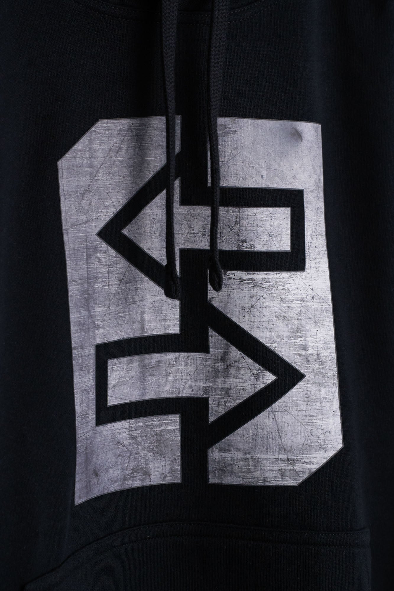 Ein schwarzer Hoodie mit einem grauen Logo darauf.
